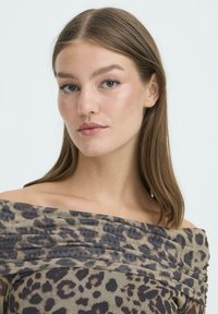 Top scollato in tessuto leggero e trasparente con motivo leopardato in tonalità di marrone e beige, caratterizzato da dettagli arricciati.