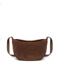 Brązowa torba na ramię z zamszu o zaokrąglonym kształcie, płaskim wierzchu i pojedynczym regulowanym paskiem. Na przodzie znajduje się subtelne logo marki.