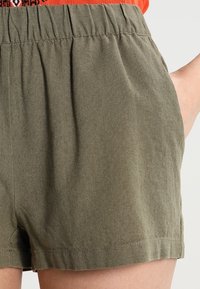 Olive zielone szorty wykonane z teksturowanej tkaniny, o luźnym kroju. W wyposażeniu elastyczny pas oraz boczne kieszenie.