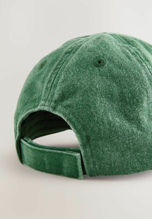Zelena tkanina baseball kapa s teksturiranim završetkom, zakrivljenim oznakom i podesivim remenom. Sadrži ventilacijske rupice i šivene detalje.