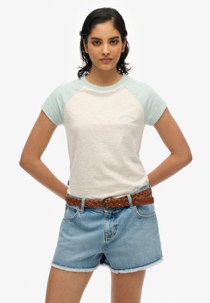 T-shirt gris clair à manches courtes avec des manches vert menthe et un logo "SUPERDRY" brodé, associé à un short en denim effiloché et une ceinture tressée marron.