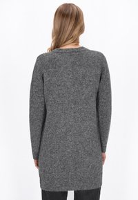 Pulover lung gri din tricot, cu decolteu rotund, mâneci lungi și o potrivire relaxată. Prezintă un finisaj texturat și un tiv care ajunge până la mijlocul coapsei.