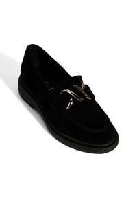 Black suede loafers with a rounded toe, a small heel, and a metallic accent. Textured surface and solid black rubber sole.