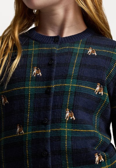 Mørkeblå cardigan med et rutemønster i grønn og gul, prydet med små broderte hundedesign og svarte knapper.