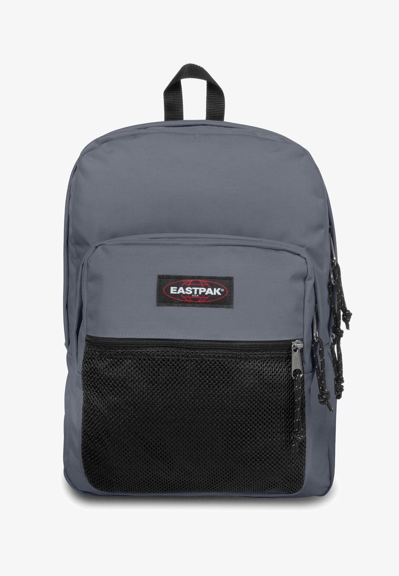 Grijze stoffen rugzak met een gaas voorvak, een handvat aan de bovenkant en ritsen. Voorzien van een zwart logo-embleem en verstelbare schouderbanden.