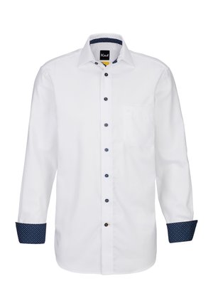 Camicia bianca a maniche lunghe con davanti uniforme, dettagli blu sui bottoni e un motivo a pois navy sui polsini e sul colletto. Una tasca sul petto.