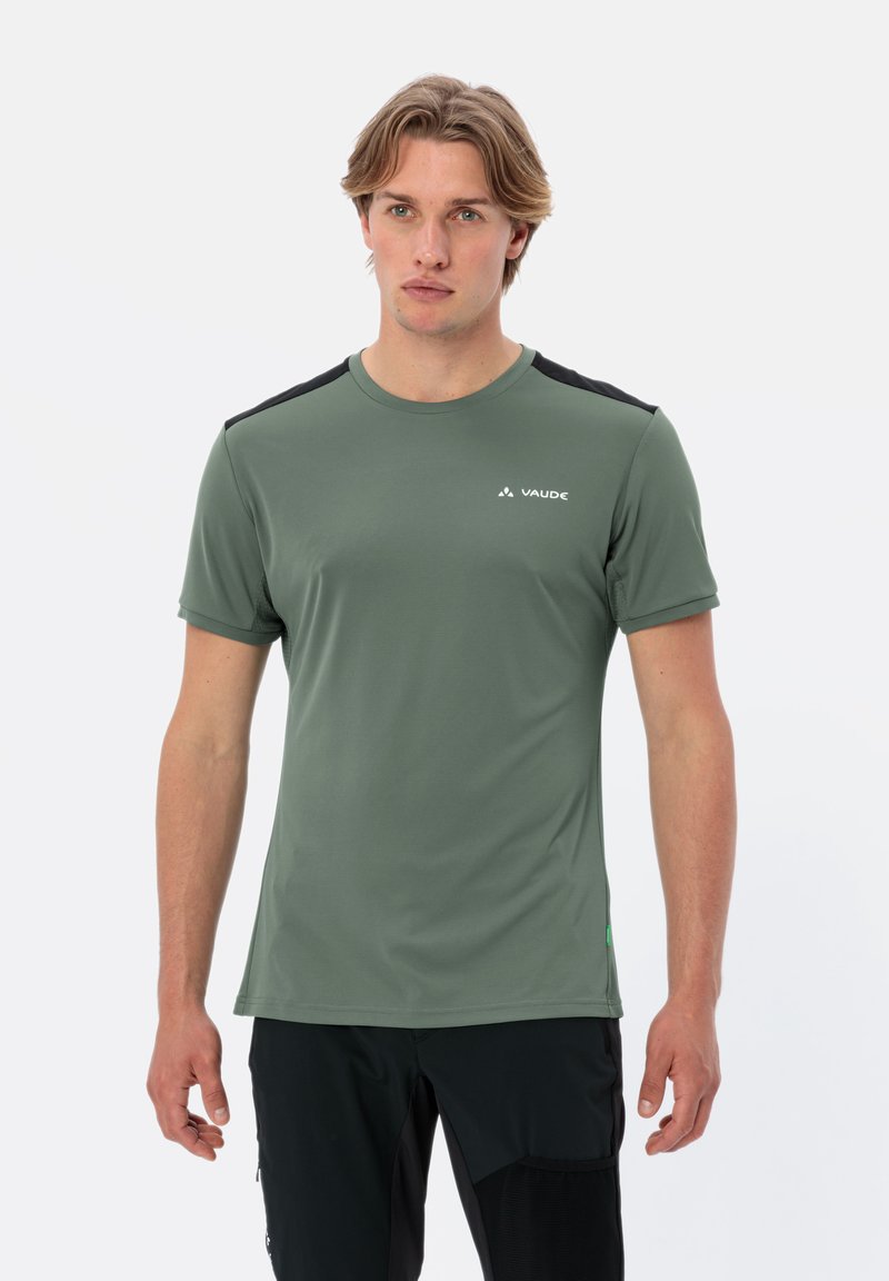 Maglietta sportiva verde a maniche corte con inserti neri sulle spalle, colletto tondo, texture liscia e un piccolo logo bianco.