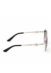 Occhiali da sole con lenti scure, montatura in metallo color oro e aste in plastica nera. Presentano accenti decorativi a metà montatura.