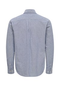 Langærmet skjorte med krave i lys blå chambray-stof. Har manchetter med knapper og en søm midt på ryggen for form. Glat tekstur.