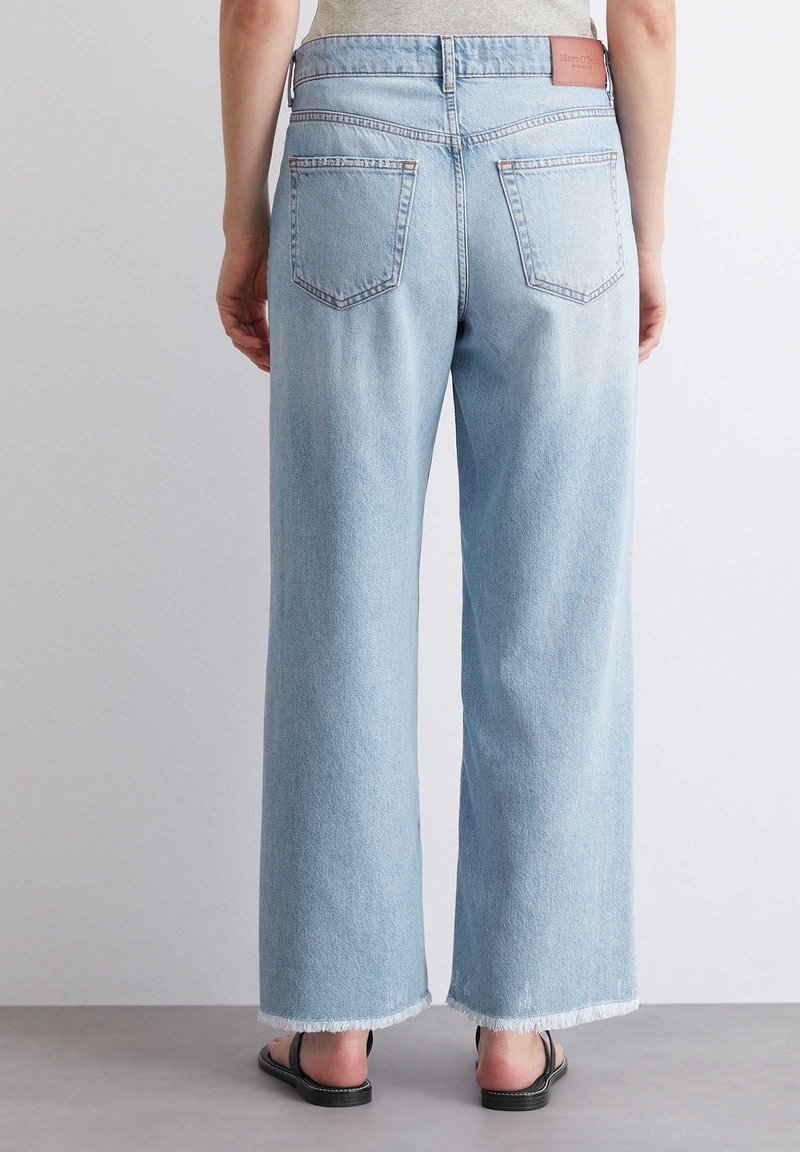 Jasnoniebieskie szerokie dżinsy wykonane z denimu, z surowym wykończeniem, dwiema tylnymi kieszeniami i skórzaną naszywką z logo na pasku.