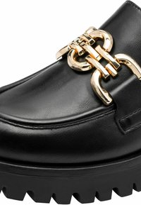 Mocassin en cuir noir avec semelle épaisse et détail important en chaîne dorée sur le dessus avant.