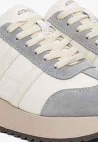 Witte en grijze sneakers met een getextureerde suède neus, katoenen veters en een stevige beige zool met een profielpatroon.