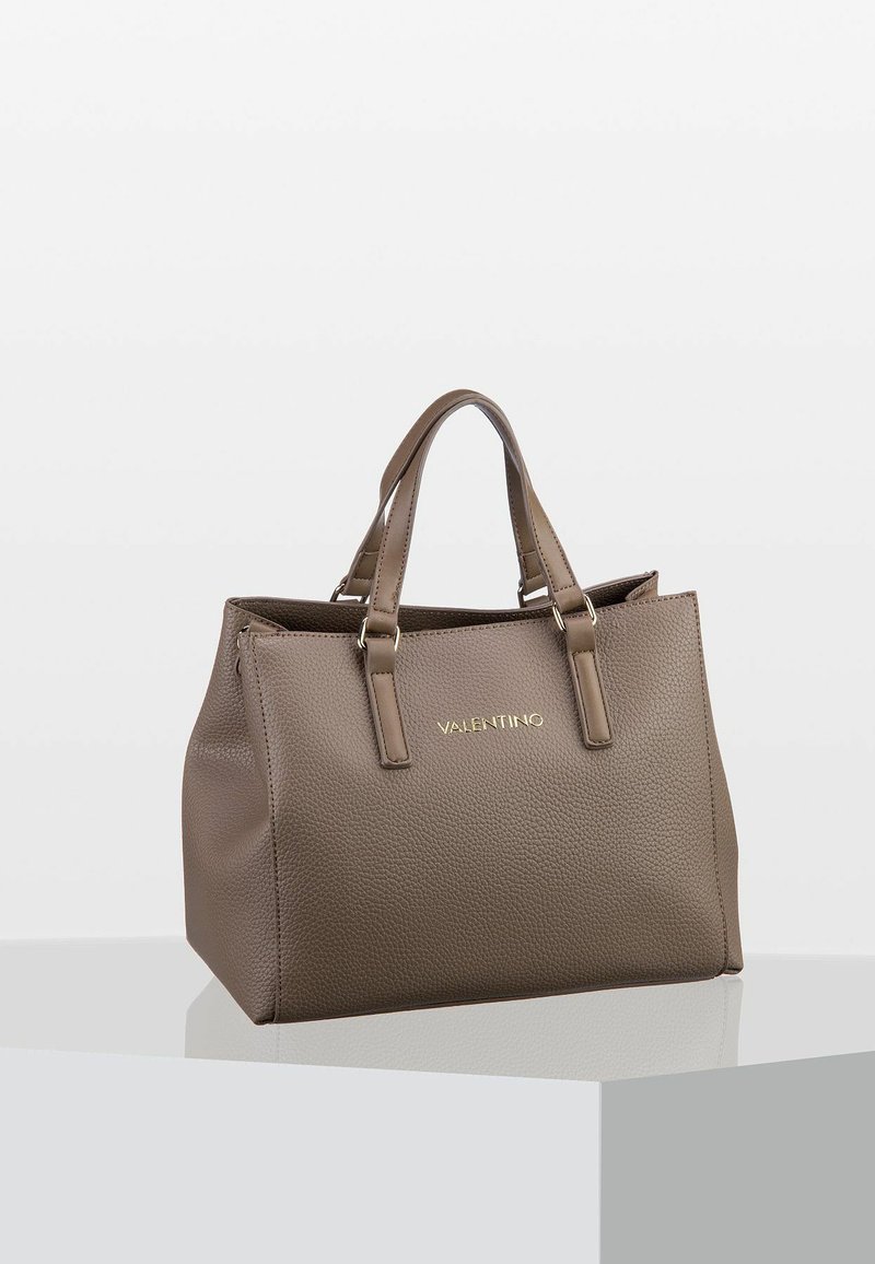 Torba Valentino w kolorze taupe z teksturowanej skóry, z dwoma uchwytami, złotym logo z przodu, prezentowana na białym pedestale na jednolitym tle.
