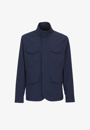 Giacca blu navy con colletto alla coreana e quattro tasche con patta, due sul petto e due sui fianchi, maniche lunghe, vestibilità aderente.