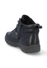 Botín de cuero negro hasta el tobillo con superficie texturizada, cierre de cordones y cremallera, suela de goma y cuello acolchado para mayor comodidad.