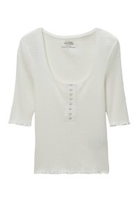 Haut blanc à manches courtes, côtelé, avec un décolleté incurvé et une rangée de six petits boutons sur le devant. Ourlet légèrement effiloché. Texture douce.