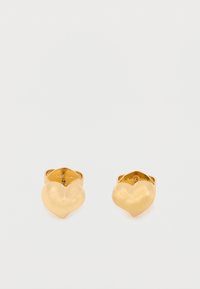 Náušnice ve tvaru srdce zlaté barvy s hladkým, lesklým povrchem. Design obsahuje jednoduchou sponu a vygravírované jméno značky na vnitřní straně.
