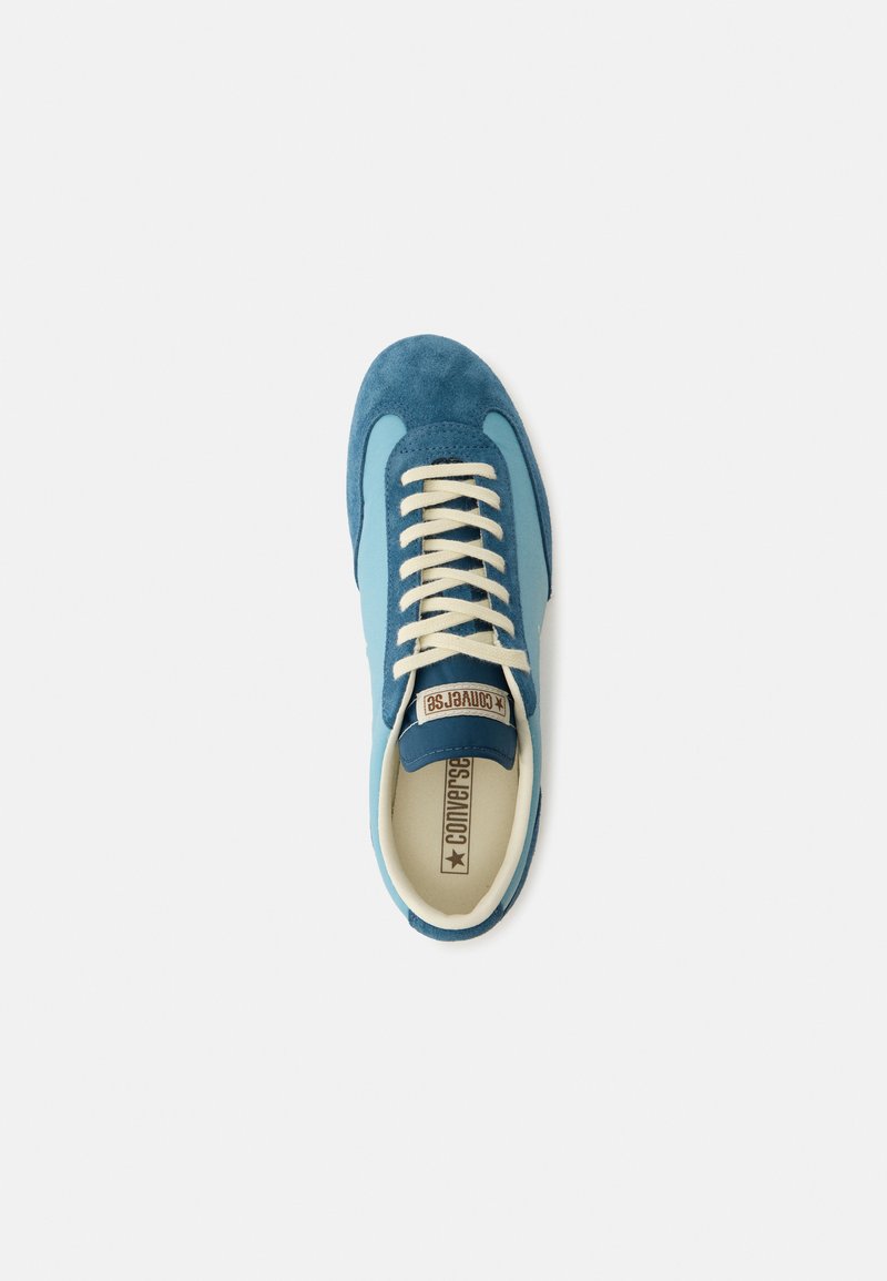 Blauer und hellblauer Wildleder-Converse-Sneaker mit weißen Schnürsenkeln, von oben auf weißem Hintergrund gesehen.