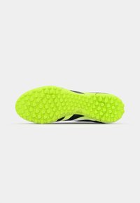 Semelle de chaussure de sport noire et vert citron avec un motif hexagonal texturé pour la traction et l'adhérence. Finition en matériau lisse et durable.