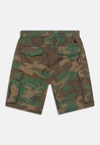 Spodnie cargo w kolorze zielonym i brązowym w kamuflażu, z elastycznym pasem i dwoma dużymi tylnymi kieszeniami z klapami. Teksturowana tkanina.