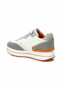 Sneaker con una toma superiore in tessuto bianco e grigio, accenti arancioni, un tallone testurizzato e una suola intermedia bianca spessa con una striscia arancione.