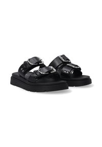 Zwarte leren sandalen met twee brede banden, elk met een zilveren gesp, rustend op een solide zwart platformzool.