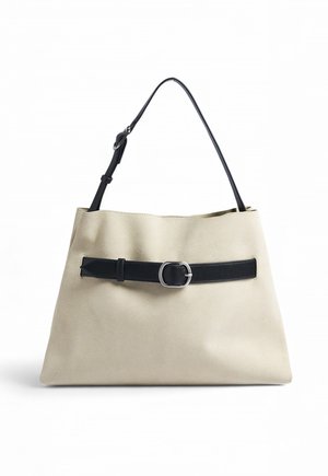 Béžová kabelka s čiernym nastaviteľným ramenným pásikom a dekoratívnym čiernym opaskom so striebornou prackou cez prednú časť.