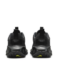 Czarne buty sportowe z teksturowaną cholewką, z pull tabem z tyłu, odblaskowymi akcentami i żółtym detalem na podeszwie.