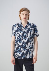 Camicia a maniche corte di colore blu navy con un motivo a foglie in bianco e tonalità di blu. Presenta un colletto e bottoni lungo la parte frontale. Tessuto leggero.