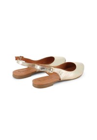 Zapatos dorados planos tipo slingback con punta redonda, parte superior texturizada y un pequeño detalle de hebilla. Plantilla suave y tacón bajo de madera.