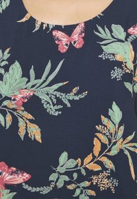 Tessuto blu navy con un motivo floreale che presenta foglie verdi, accenti arancioni e farfalle rosa di diverse dimensioni. Texture liscia.