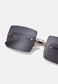 Sunglasses with dark rectangular lenses, gold metal frame, and transparent temple tips. Features a thin bridge connecting the lenses.