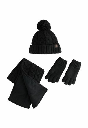 Ensemble d'hiver noir en tricot comprenant un bonnet avec pompon, une écharpe en tricot torsadé doublée en polaire, et des gants à poignets côtelés sur fond blanc.