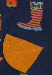 Bunte Baumwollsocken mit marineblauem Hintergrund; zeigt Muster aus gestreiften Gummistiefeln und Kürbissen; orangefarbene Fersen- und Zehenbereiche.