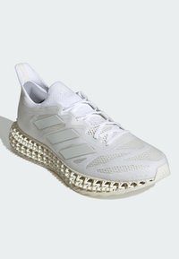 Scarpa atletica bianca con tomaia in mesh, motivo testurizzato, tre strisce laterali e una suola intermedia di forma a griglia unica. Presenta una chiusura con lacci.
