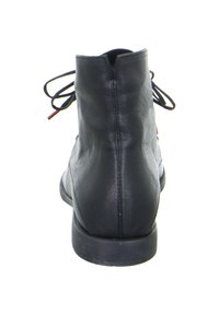 Botas de cuero negro hasta el tobillo con una textura suave, punta redondeada y tacón estrecho. Presentan cordones atados y un diseño minimalista.