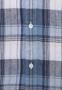 Blå- och vit rutig skjorta med knappar, med tunna gula och marinblå linjer; har två knappar med en slät, vävd textur.