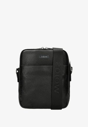 Czarna torebka typu crossbody z fakturowanego tworzywa sztucznego, z zamkiem błyskawicznym, przednią kieszenią oraz szerokim paskiem z wytłoczonym logo.