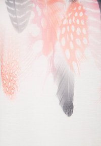 Tričko s bílým základem a gradientním designem korálových a šedých per, který ukazuje složité vzory a jemnou texturu.