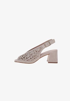 Sandalia slingback de ante beige con recortes geométricos, detalles con pedrería, puntera abierta, correa ajustable con hebilla y tacón medio en bloque.