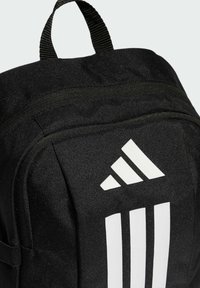 Czarny plecak wykonany z trwałego materiału o teksturowanej powierzchni. Posiada trzy białe pionowe paski i trójkątne logo z przodu.