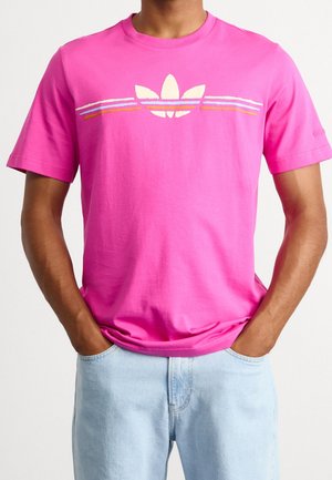 Pink cotton t-shirt with short sleeves featuring a white Adidas logo and three horizontal stripes in blue, orange, and pink across the chest.