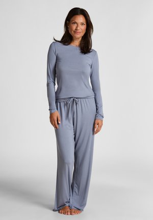 Ensemble de loungewear gris clair comprenant un haut à manches longues et un pantalon ample, fabriqué en tissu doux et lisse avec une taille élastique.