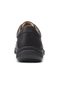 Schwarzer Lederschuh mit rundem Absatz, strukturierter Oberfläche und kontrastierenden Nähten. Verfügt über ein gepolstertes Innenleben und eine flexible Sohle.