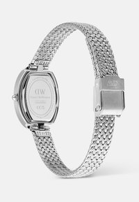 Silver Daniel Wellington watch with woven metal strap, rectangular case back, and clasp engraved with "MD" initials.