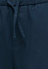 Pantalons en lin bleu marine avec une taille élastique et un cordon de serrage, une poche latérale et une finition lisse.