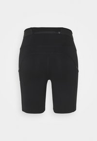 Shorts de sport noirs taille haute avec une petite poche zippée à l'arrière et des coutures latérales visibles.