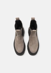 Botas de tobillo de ante gris con paneles laterales elásticos negros y una suela de goma texturizada negra. Tiradores en la parte trasera para facilitar su uso.