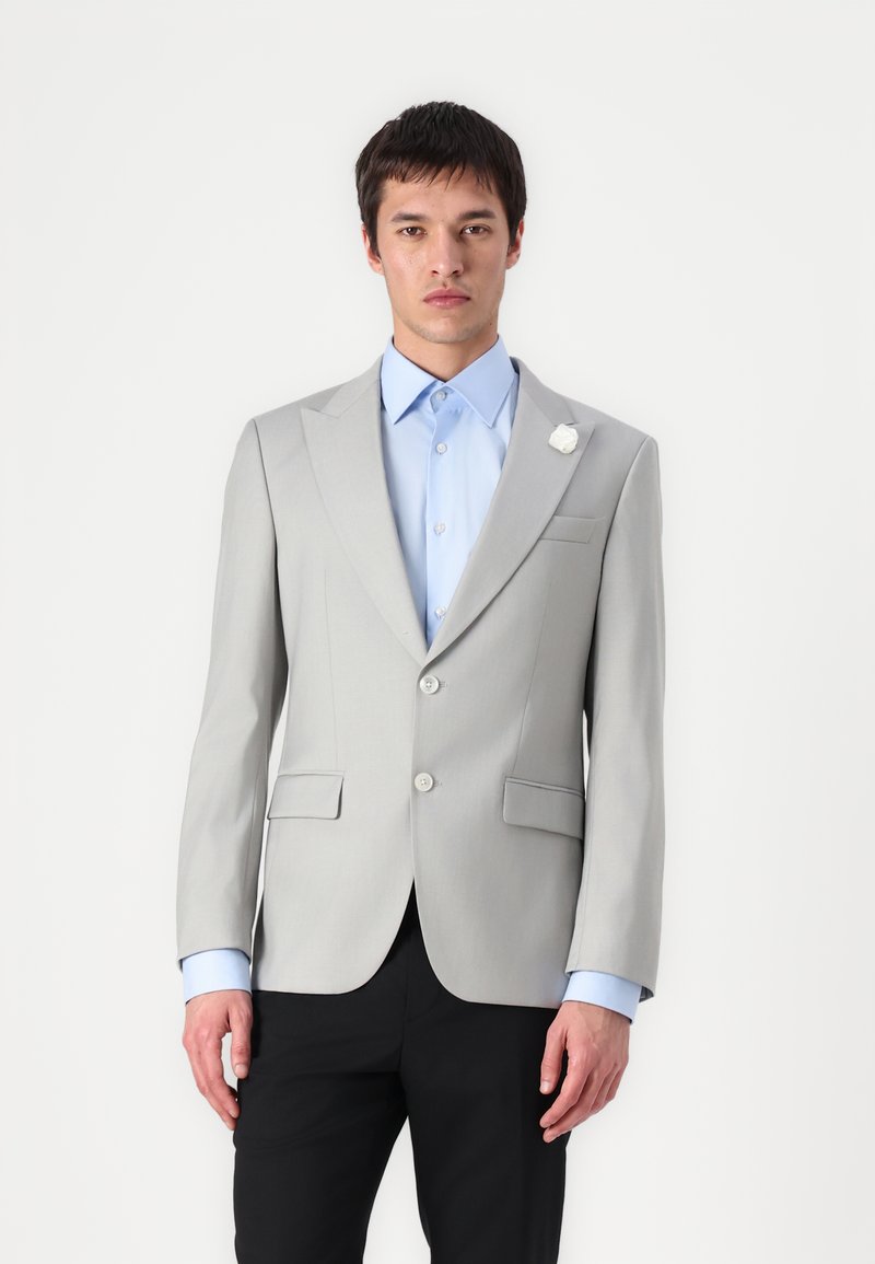 Grijze op maat gemaakte blazer met notch revers, enkele knoopsluiting en twee voorkeurszakken, gecombineerd met een lichtblauw overhemd en zwarte broek.
