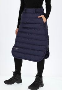 Tummansininen, eristetty, toppahame, jossa on vaakasuuntainen tikkauskuvio, varustettu vetoketjullisilla sivutaskuilla ja pyöristetyllä helmalla alareunassa.